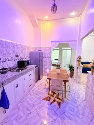 a kitchen with a wooden table in a room at Appart Cosy Près de laéroport Adapté au Famille in Marrakech