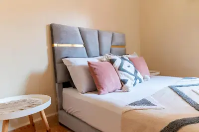 a bed with pink and blue pillows on it at Appartement à Marrakech in Marrakech