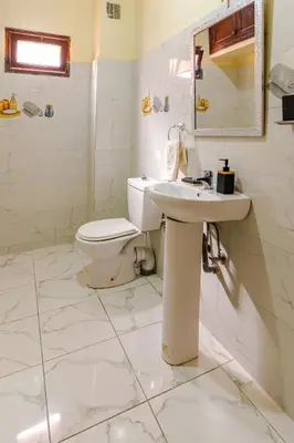 a white bathroom with a toilet and a sink at Appartement à Marrakech in Marrakech