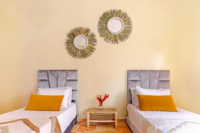 two beds in a room with mirrors on the wall at Appartement à Marrakech in Marrakech