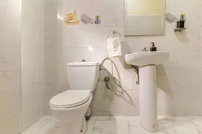 a white bathroom with a toilet and a sink at Appartement à Marrakech in Marrakech