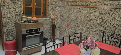 a kitchen with a stove and a table with a table sidx sidx at cozy Apartment Near Airport in Marrakech