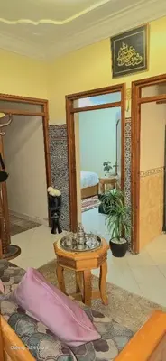 a living room with a bed and a table and a mirror at cozy Apartment Near Airport in Marrakech