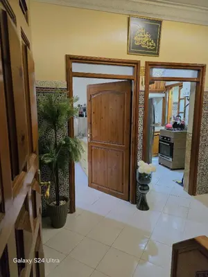 a hallway with a wooden door and a kitchen at cozy Apartment Near Airport in Marrakech