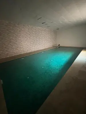 a swimming pool with green water in a room at Cosy-Appart in Marrakech