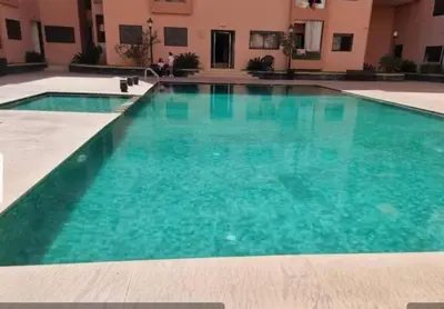 a large pool with blue water in a building at Cosy-Appart in Marrakech