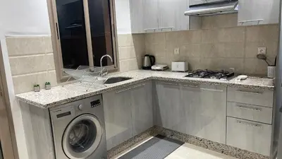 a kitchen with a washing machine and a sink at Duplex chic et cosy avec piscine in Marrakech
