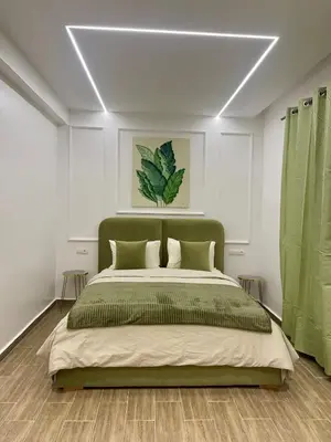 a bedroom with a large bed with green curtains at Duplex chic et cosy avec piscine in Marrakech