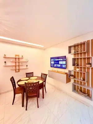 a dining room with a table and chairs and a tv at STUDIO luxueux COSY FAMILY in Marrakech