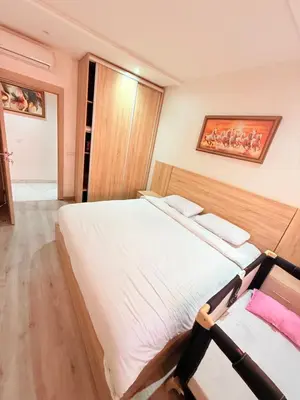 a bedroom with a large bed and a painting on the wall at STUDIO luxueux COSY FAMILY in Marrakech