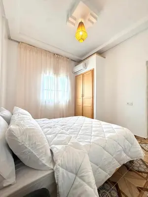 a large white bed in a bedroom with a window at Neuf appartement a marrakech in Marrakech