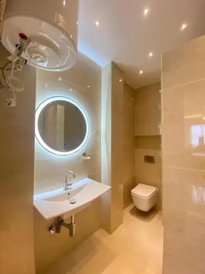 a bathroom with a sink and a toilet and a mirror at Neuf appartement a marrakech in Marrakech
