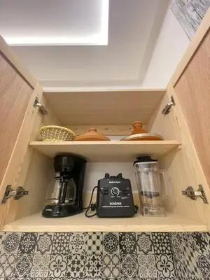a kitchen cupboard with a blender and a toaster at Neuf appartement a marrakech in Marrakech