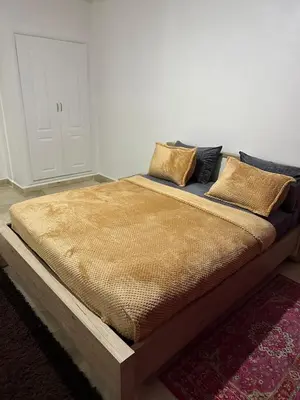 a bed with a wooden frame in a room at le spacieux 37 pour familles face gare CTM Hivernage in Marrakech
