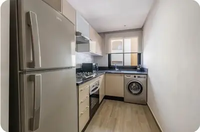 a kitchen with a refrigerator and a washing machine at Grand appartement deux terrasses in Marrakech