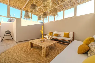 a living room with a couch and a table at Grand appartement deux terrasses in Marrakech
