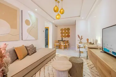 a living room with a couch and a tv at Grand appartement deux terrasses in Marrakech