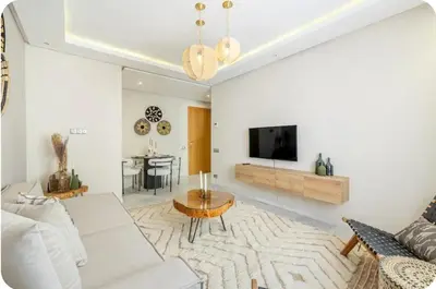 a living room with a white couch and a tv at Appartement en hyper Centre in Marrakech