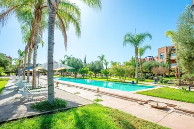 a swimming pool with palm trees and a resort at Luxury Apartment in Vizir Park & Resort in Marrakech