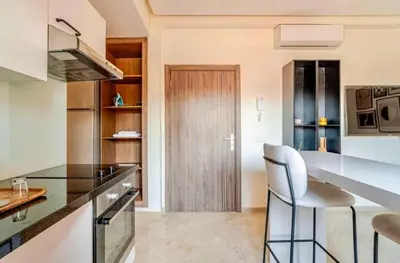 a kitchen with a counter and a bar with a chair at Appart Chambre et Salon Gueliz Marrakech Alia1 in Marrakech