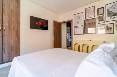 a bedroom with a white bed and a tv on the wall at Appart Chambre et Salon Gueliz Marrakech Alia1 in Marrakech