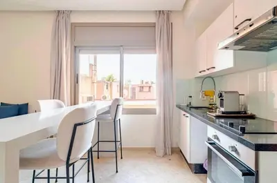 a kitchen with a counter and chairs and a window at Appart Chambre et Salon Gueliz Marrakech Alia1 in Marrakech