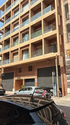 a parking lot with cars parked in front of a building at Appart Chambre et Salon Gueliz Marrakech Alia1 in Marrakech