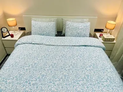 a bedroom with a large bed with blue sheets and pillows at Appartement à Marrakech in Marrakech