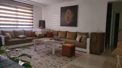 a living room with a couch and a table at Le Confortable a 15mn de L'aéroport interdit au couples non marié in Marrakech