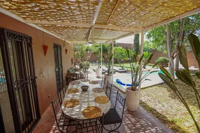 a patio with a table and chairs and a pool at Villa Em in Marrakech