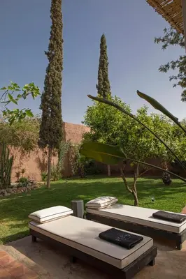 two beds in a garden with trees and grass at Villa Em in Marrakech