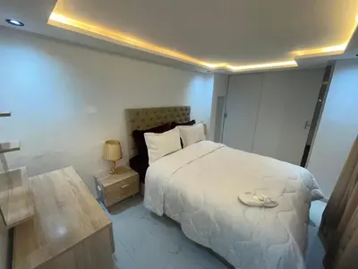 a bedroom with a large white bed and a table at Duplexe de luxe Gueliz in Marrakech