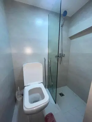 a bathroom with a toilet and a glass shower at Duplexe de luxe Gueliz in Marrakech