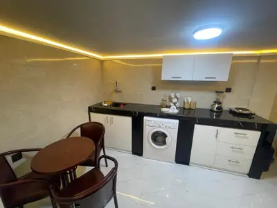a kitchen with a washing machine and a table and chairs at Duplexe de luxe Gueliz in Marrakech