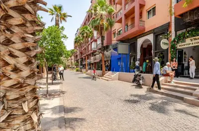 a street in a city with people walking down the street at Sojori Majorelle piscine et parking in Marrakech