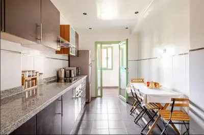 a kitchen with a table and some chairs in it at Sojori Majorelle piscine et parking in Marrakech