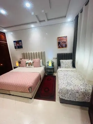 a bedroom with two beds in a room at Dar Nahila Appartement Aéroport in Marrakech