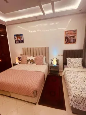 two beds in a bedroom with two lamps at Dar Nahila Appartement Aéroport in Marrakech