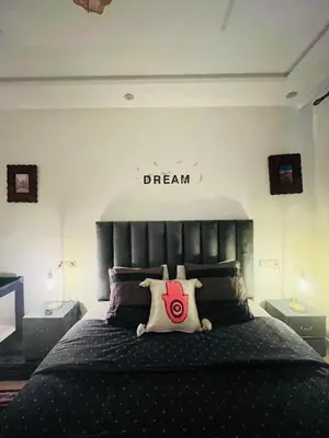 a bedroom with a bed with a dream sign on the wall at Dar Nahila Appartement Aéroport in Marrakech