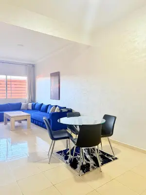 a living room with a blue couch and a table at Charmant Studio B5 & Bel Terrasse in Marrakech