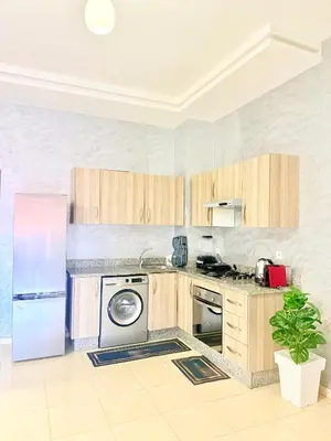 a kitchen with wooden cabinets and a refrigerator at Charmant Studio B5 & Bel Terrasse in Marrakech