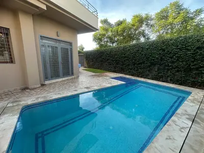 a swimming pool in front of a house at Dar Zoubida in Marrakech