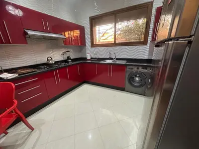 a kitchen with red cabinets and a washing machine at Dar Zoubida in Marrakech