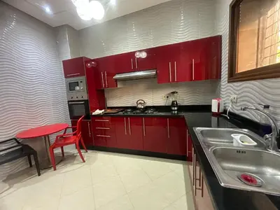 a kitchen with red cabinets and a sink and a red chair at Dar Zoubida in Marrakech
