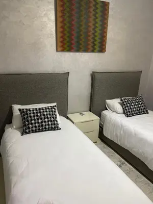 a bedroom with two beds and a painting on the wall at Élégant appart 2chambre, terrasses,proche Gueliz&parking in Marrakech