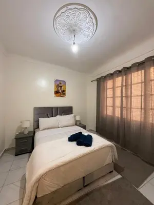 a bedroom with a large bed with blue pillows on it at Appartement Salia à Guéliz Marrakech in Marrakech
