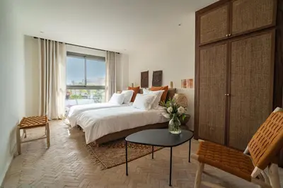 a bedroom with a bed and a vase of flowers on a table at Villa 61 in Marrakech