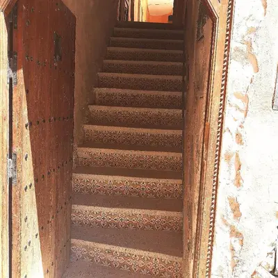 a set of stairs in a building with a wooden door at BAHIA BIKE APPART 1 - Terrasse in Marrakech