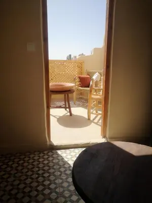 a door open to a balcony with a table and chair at BAHIA BIKE APPART 1 - Terrasse in Marrakech