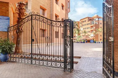 an ornate black gate in a city with buildings at la cocon paisible de Marrakech in Marrakech